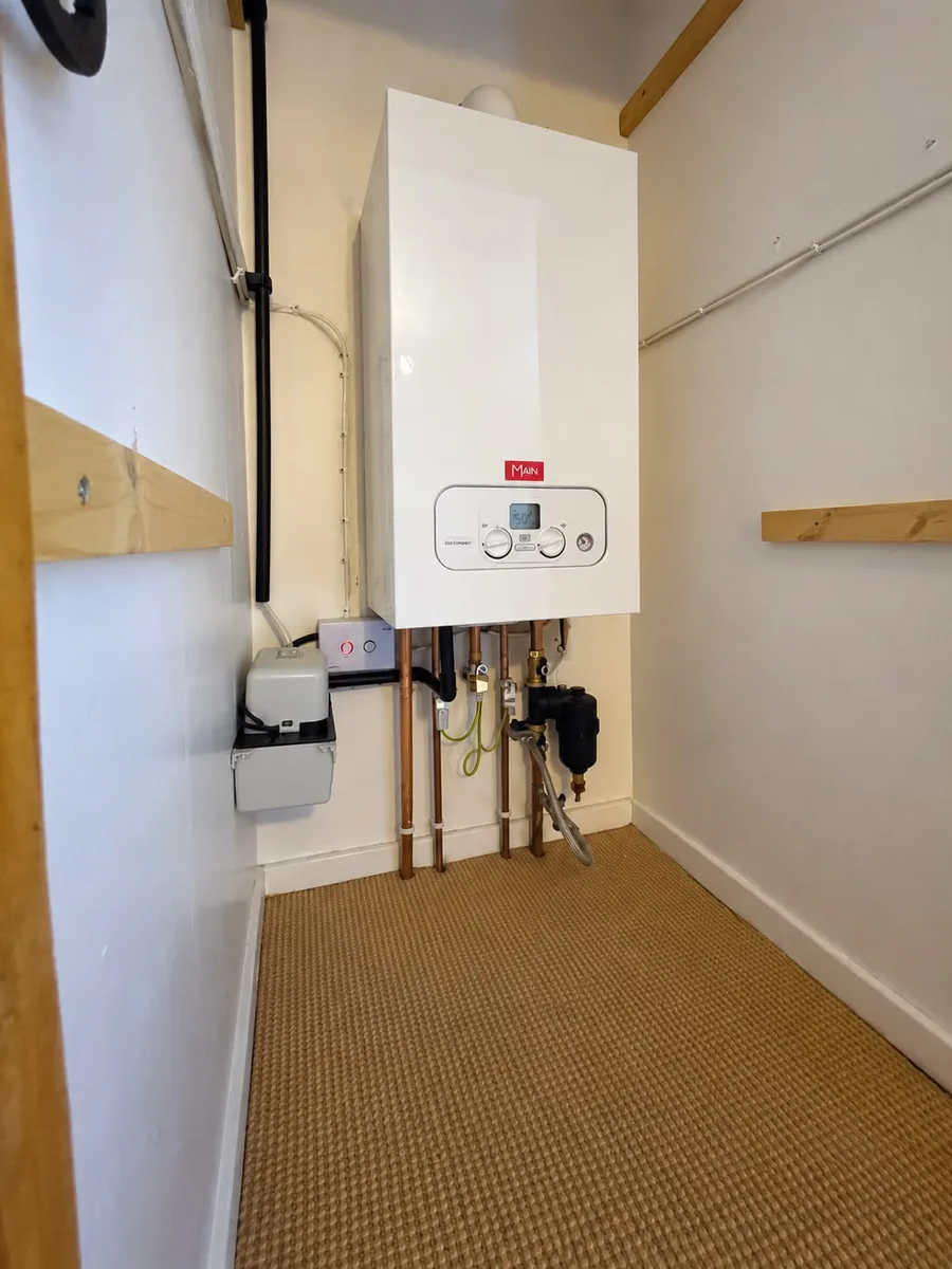 Combi boiler fitted in a cupboard with a magnetic filter and condensate pump, by TF Heating